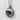 Close-up of the oxidized silver dolphin pendant highlighting the intricate gemstone setting against a textured stone wall.