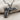 High-quality sterling silver pistol and rose pendant resting on textured fabric highlighting the oxidized finish.