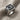 Detailed view of sterling silver initial signet ring resting on textured linen fabric showing floral side engravings.