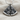Close-up of the interlocking 925 sterling silver split pizza pendant resting on a textured woven fabric background