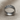 Angled view of the handcrafted cherry blossom ring resting on textured fabric highlighting the detailed sakura branches