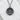 Sakura blossom medallion pendant, oxidized silver, front view on white stone