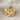 Close-up of two-tone plumeria flower pendant featuring 14K gold vermeil blossom over oxidized silver disc on soft fabric