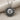 Close-up of the oxidized silver celestial sun pendant with peaceful facial details resting on a textured fabric surface.