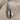 Close-up of premium 925 sterling silver cowrie shell earring resting on textured beige linen fabric