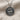Detailed angled view of two-tone sterling silver swimmer medallion showing deep engraved water waves and dark patina