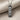 Close-up of handcrafted swim mantra pendant resting on textured fabric highlighting the Seigaiha wave engraving details