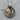 Two-tone 925 sterling silver sun and moon pendant resting on a wooden surface highlighting intricate carved faces