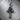 Close-up of oxidized silver crowned cross pendant resting on a textured wooden surface highlighting artisanal metalwork