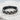 Artisan crafted oxidized silver braided ring resting on textured stone, highlighting the deep woven details
