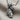 Close-up of handcrafted microphone pendant resting on textured fabric, highlighting the intricate mesh grill details