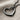 Detailed view of the oxidized silver open heart pendant resting on textured fabric highlighting craftsmanship