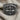 Close-up perspective of gothic Maltese cross ring with intricate carved patterns resting on beige linen