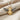 Detailed close-up of oxidized silver wings and gold vermeil body of the honeybee pendant on linen fabric