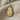 Close-up of gold vermeil Hamsa hand pendant with oxidized silver backing on textured linen fabric background