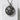 Close-up of the handcrafted military skull pendant resting on a textured white stone surface