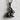 Sitting Rabbit Pendant in black rhodium, product photo against textured wall