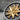 Macro detail of two-tone Masonic Blazing Star ring resting on stone showing oxidized silver and gold finish