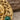 Close-up detail of hand-finished gold Medusa pendant showcasing intricate serpent scales and malachite cabochon