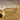 Extreme macro close-up of hand-finished feather details and textured craftsmanship on gold wing pendant