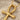 Close-up view of handcrafted ankh pendant showing fine polished detail and craftsmanship on fine white sand