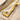 Braided Viking Axe Pendant, gold vermeil, angled view on sand