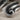 Draped Volute Open Ring, oxidized, close-up of scroll terminal and fanned folds