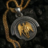 Reversible silver angel demon pendant showing the gold-plated archangel side with 'Light Against Darkness' inscription.