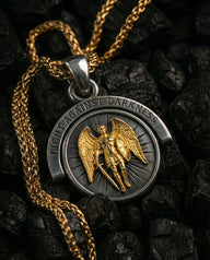 Reversible silver angel demon pendant showing the gold-plated archangel side with 'Light Against Darkness' inscription.