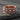 Rose gold plated variation of the heraldic skull ring design displayed on a textured stone surface