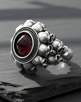Side profile of the sterling silver skull ring showcasing the detailed, small skulls forming the band, with dramatic lighting.