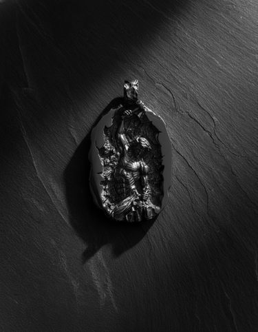 Black rhodium plated silver self made man pendant showing figure carving himself from stone