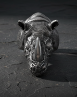Top view of heavy silver rhinoceros ring highlighting the polished horn and rough skin texture on slate background