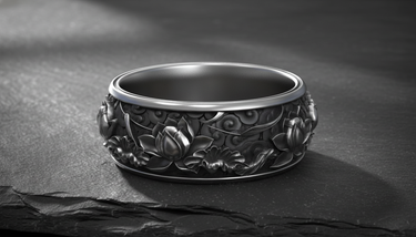 Angled close-up of wide silver ring featuring blooming lotus and swirling cloud designs