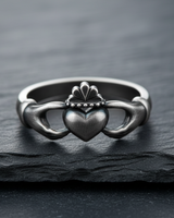 Angled side view of handcrafted silver Claddagh ring showing hands holding heart and oxidized finish details