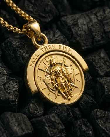 Gold vermeil Resurgent Knight pendant showing standing warrior and Fall Then Rise text on charcoal