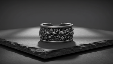Adjustable silver skull band ring displaying intricate skeleton heads and beaded rim details