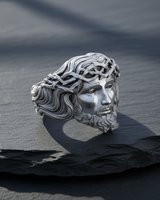 Polished 925 sterling silver Jesus ring showcasing the detailed face of Christ and the Crown of Thorns, styled on a dark slate surface.