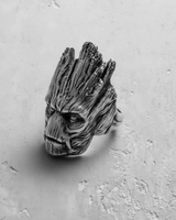 Angled view of sterling silver tree man ring highlighting the jagged top and expressive facial details
