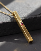 Gold vermeil over 925 sterling silver vertical bar pendant with rough brutalist texture and ruby colored stone