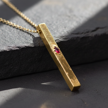 Gold vermeil over 925 sterling silver vertical bar pendant with rough brutalist texture and ruby colored stone