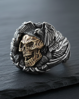 Close-up of handcrafted sterling silver ring showing intricate eagle feathers and gothic skull texture
