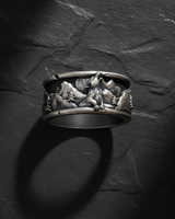 Close-up of wolf howling at the moon relief design on oxidized sterling silver nature themed ring band
