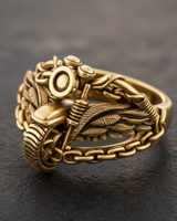 Gold vermeil motorcycle ring featuring bike front wings and chain band design on dark background