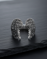 Front view of oxidized sterling silver angel wings ring showing open shank design and intricate feather carving