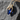 Gold vermeil silver gothic hands pendant holding blue teardrop gemstone on dark stone background