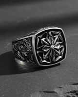 Angled side view of silver ring displaying deep relief acanthus scrollwork and oxidized antique finish