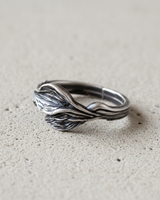 Side view of sterling silver leaf ring showing the wrapping leaf stems and comfortable band thickness on stone surface
