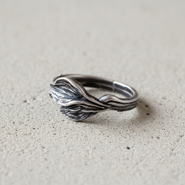 Side view of sterling silver leaf ring showing the wrapping leaf stems and comfortable band thickness on stone surface