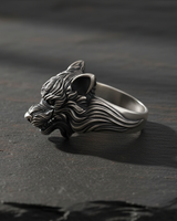 Profile view of sterling silver wolf ring highlighting intricate carving and ear details on slate surface